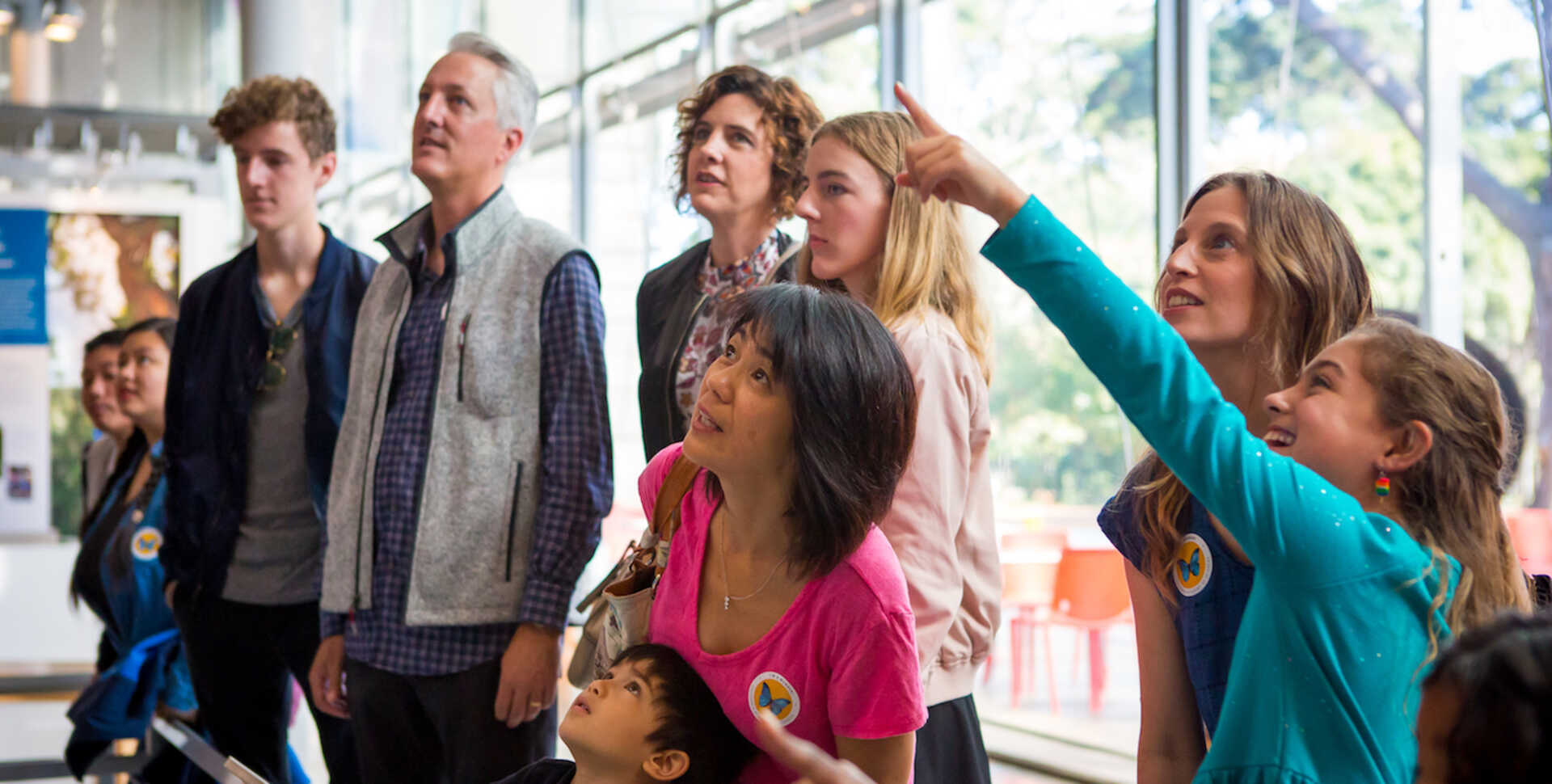 Members watching Gouldian finches in the Color of Life exhibit at the California Academy of Sciences