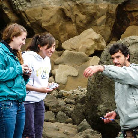 Students in the Summer Systematics Institute are shown a sea creature by a researcher. 