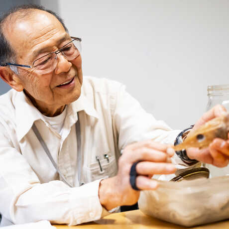 Academy curator Tomio Iwamoto holds a preserved grenadier fish specimen. Photo by Gayle Laird