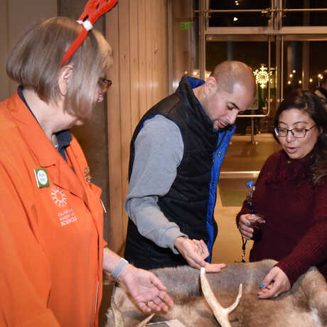 Academy docent demonstrates animal pelt to guests during an event