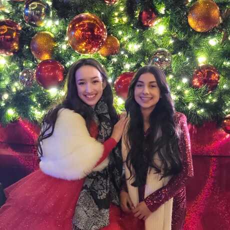 Performers Alliana and Melissa in front of Christmas tree