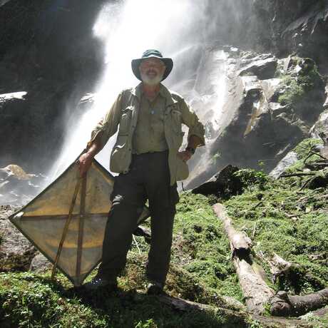 Entomologist Dave Kavanaugh on expedition with a waterfall in background
