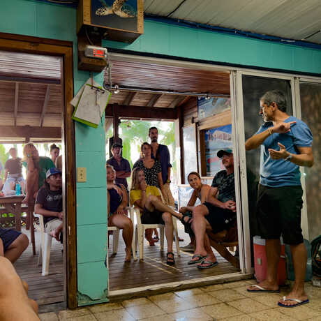 Academy researcher Luiz Rocha presents on recent findings to a dive shop in Roatán