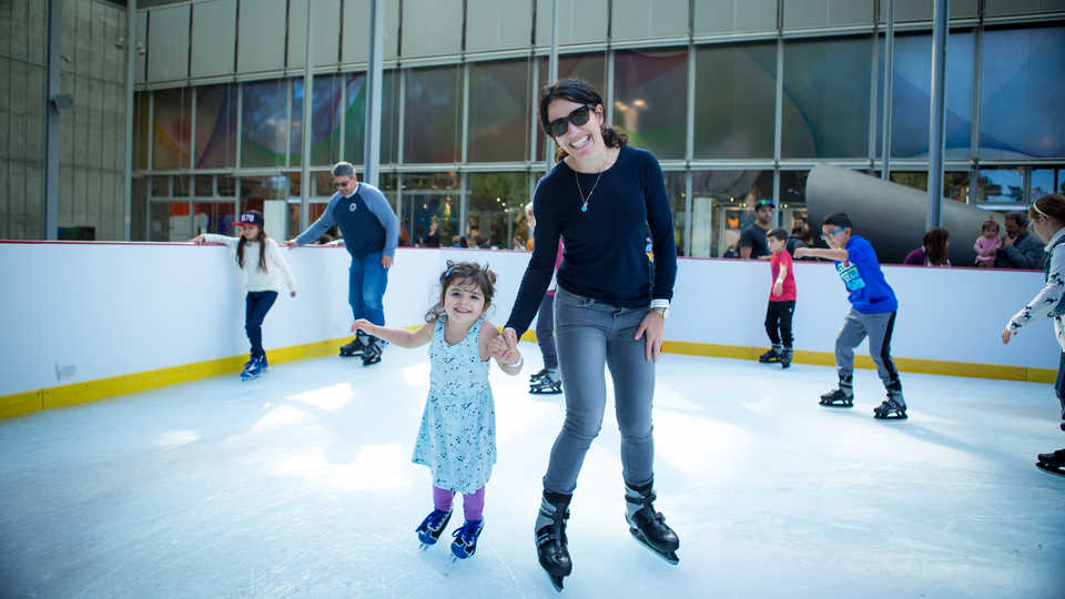 A mother and daughter ice skate at the new holiday ice rink at the Academy
